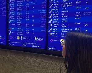 Invercargill woman Michelle Watts views a crammed arrivals and departures schedule at Doha...